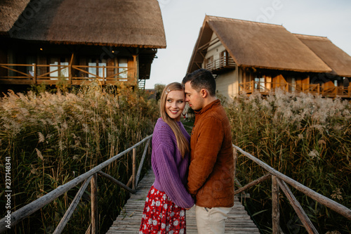Happy couple posing in front of wooden house