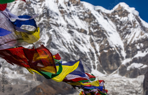 Close-up of Colorful tibetan prayer flags moved by the wind and with blurred background of Annapurna 1, Himalayas