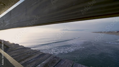 view of the ocean from the fishing looking through the railing 3