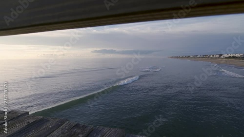 view of the ocean from the fishing looking through the railing 1