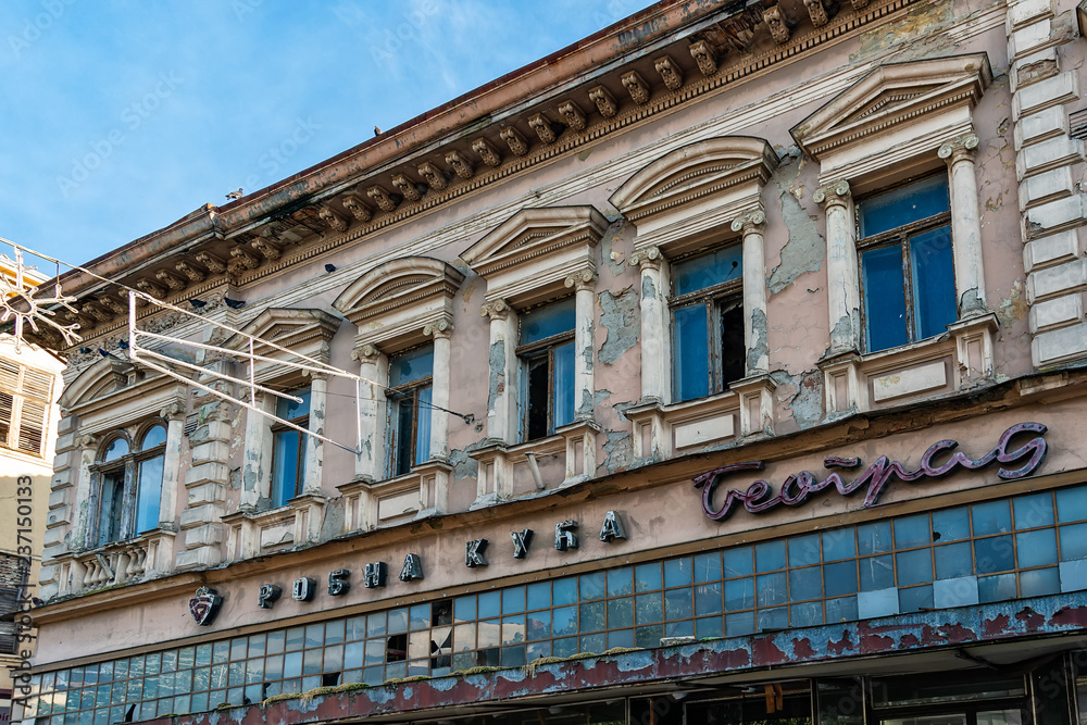 Zrenjanin, Serbia - May 17, 2018: Serbian town of Zrenjanin main pedestrian street. An abandoned building in the center of a formerly famous company Zrenjanin, Serbia - May 17, 2018: Serbian town of Zrenjanin main pedestrian street. An abandoned building in the center of a formerly famous company