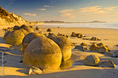 Photo The Moeraki Boulders are unusually large and spherical boulders lying along a stretch of Koekohe Beach on the wave cut Otago coast of New Zealand between Moeraki and Hampden