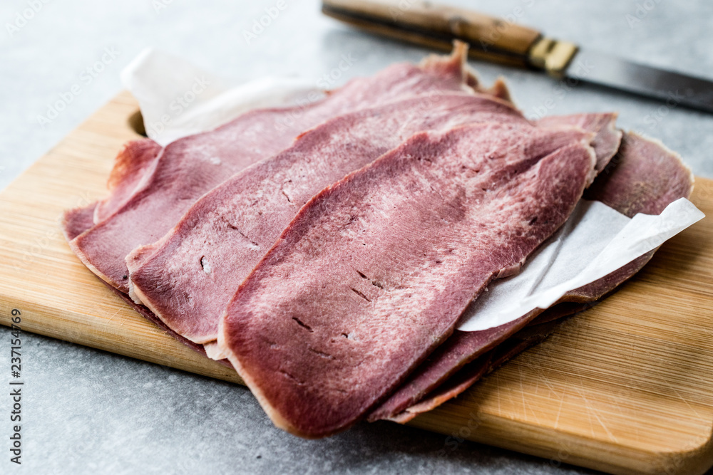 Sliced Beef Tongue Slices on Wooden Board.