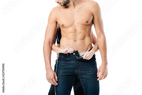 Tableau sur toile cropped view of woman unzipping pants on man from behind isolated on white