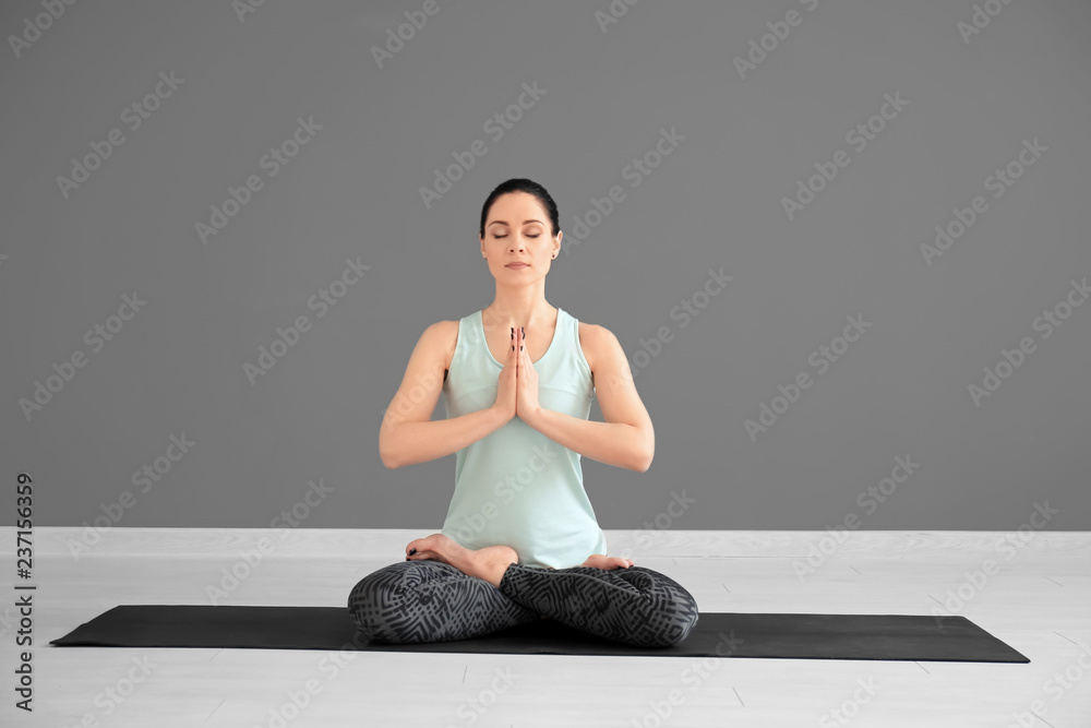 Fototapeta premium Young woman practicing yoga indoors