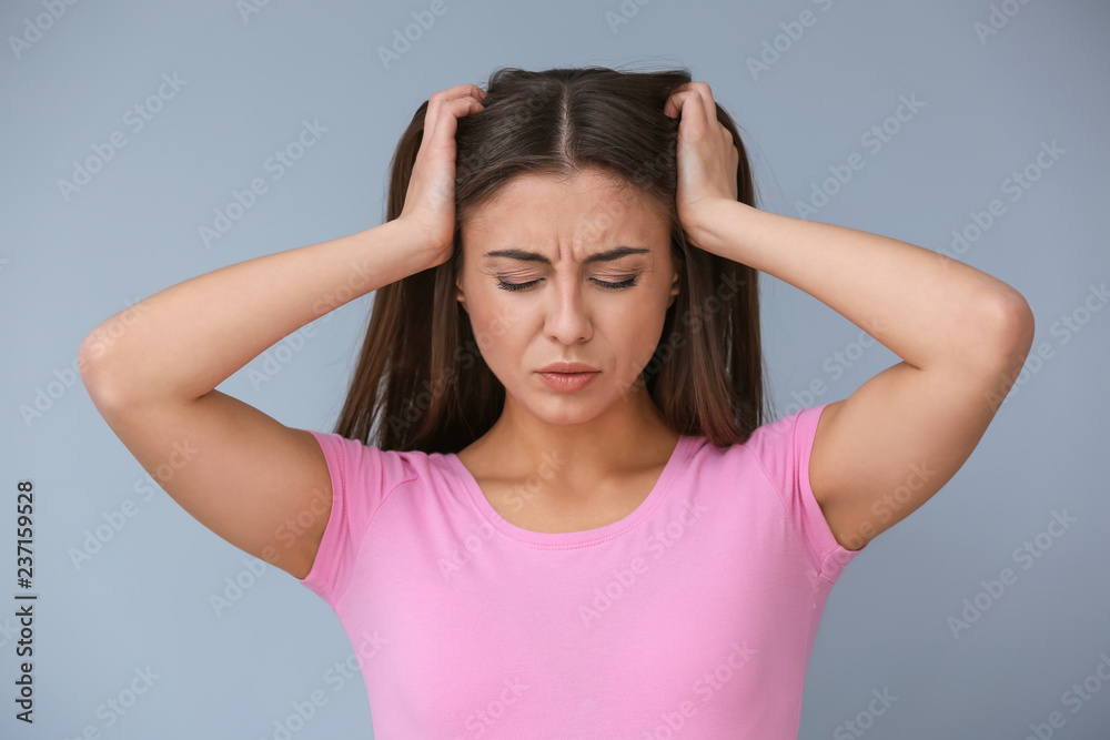 Woman suffering from headache on color background Woman suffering from headache on color background