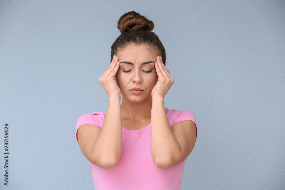 Woman suffering from headache on color background Woman suffering from headache on color background
