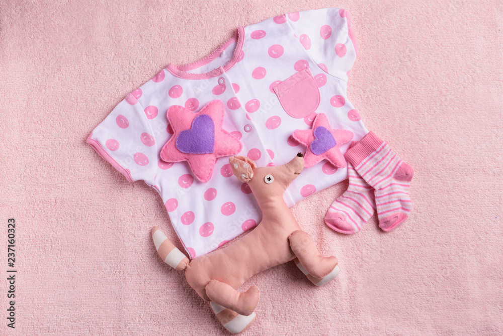 Baby clothes and toys on color towel, top view Baby clothes and toys on color towel, top view