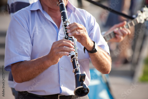 Fotografiet man playing clarinet on street