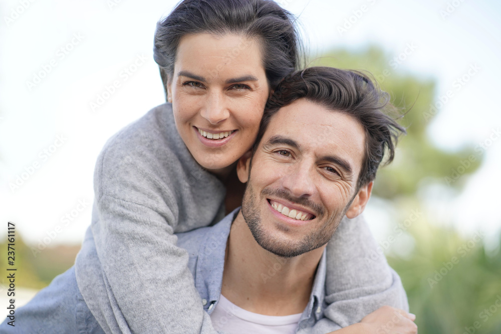 Portrait of gorgeous couple outdoors piggybacking Portrait of gorgeous couple outdoors piggybacking