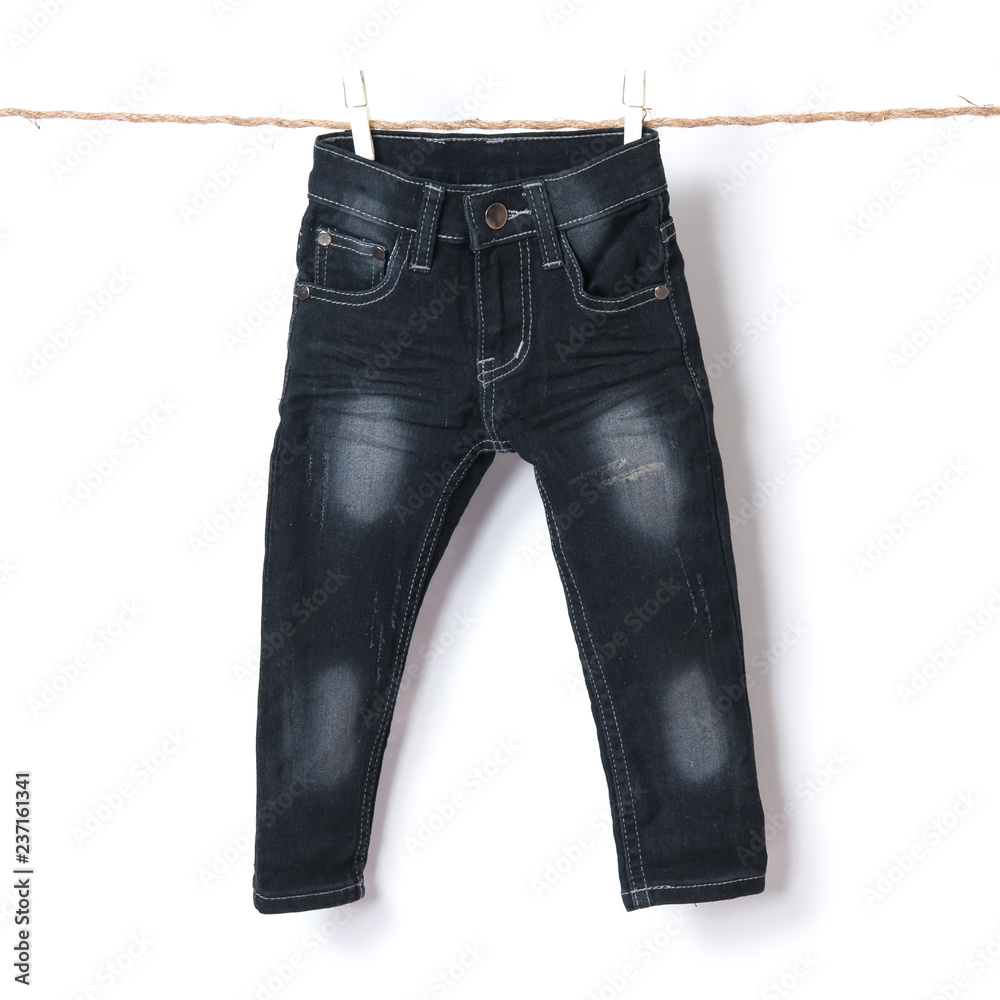 Baby jeans hanging on the clothesline against white background Baby jeans hanging on the clothesline against white background