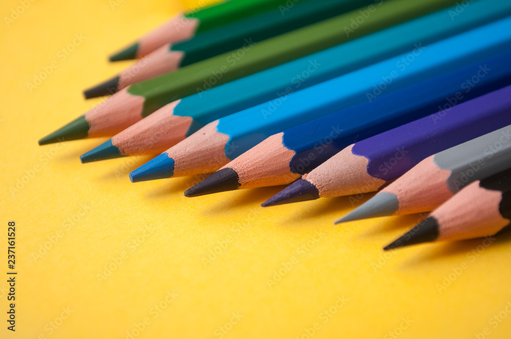Fototapeta premium closeup of colouring pencils on yellow background