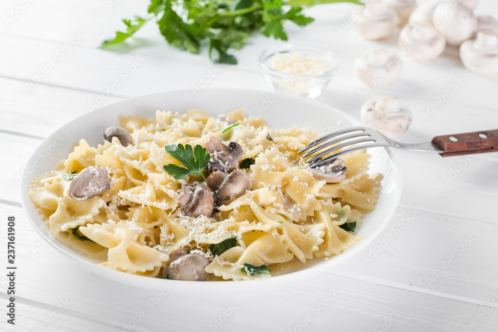 Close up pasta with mushroom and parsley on white wooden table.