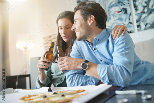  Happy relaxed couple sharing a pizza at home