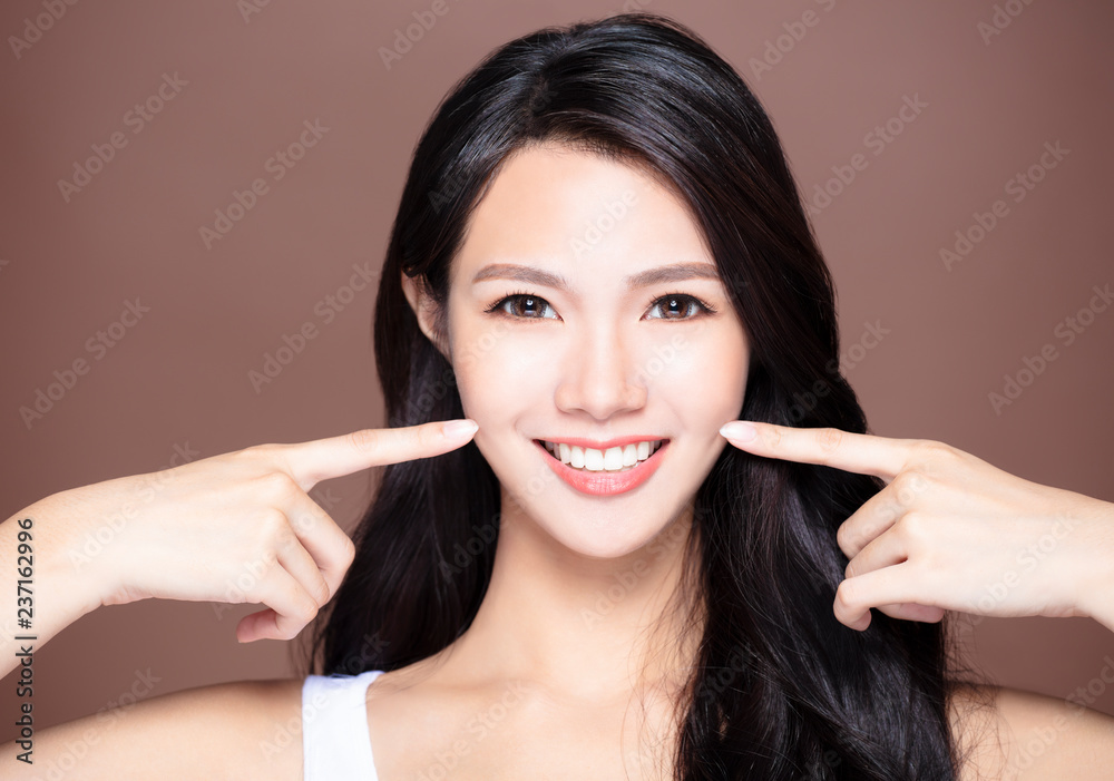 smiling young asian woman showing her teeth smiling young asian woman showing her teeth