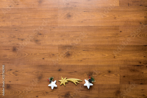 Christmas ornaments including stars over wooden background