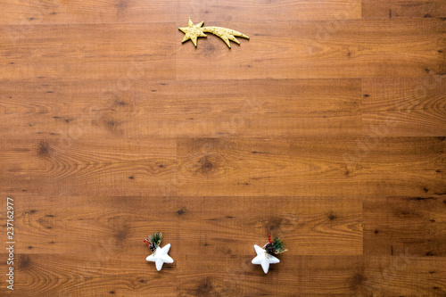 Christmas ornaments including stars over wooden background