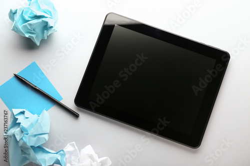 Tablet computer and crumpled paper on white background. Mistake concept