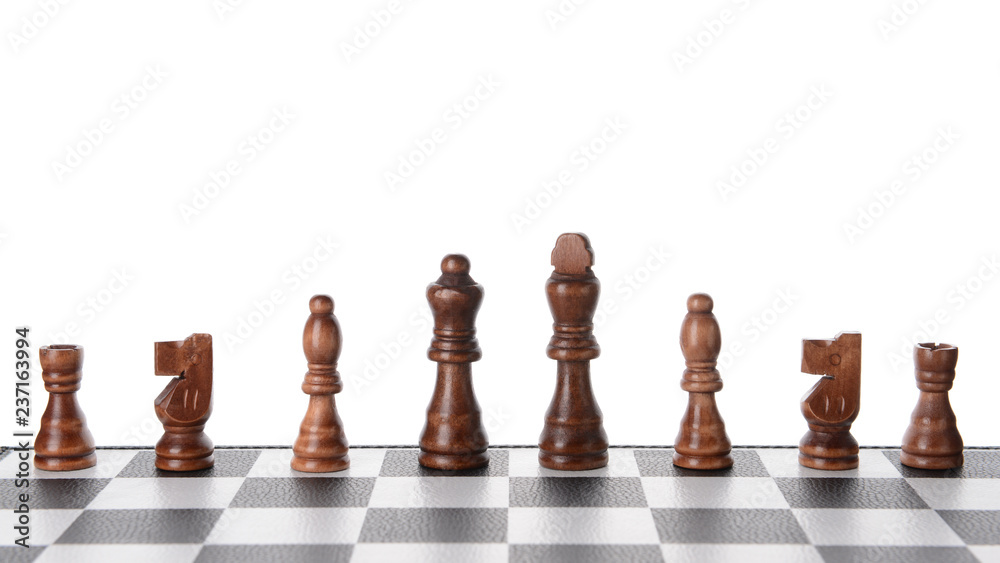 Chess pieces on game board against white background Chess pieces on game board against white background