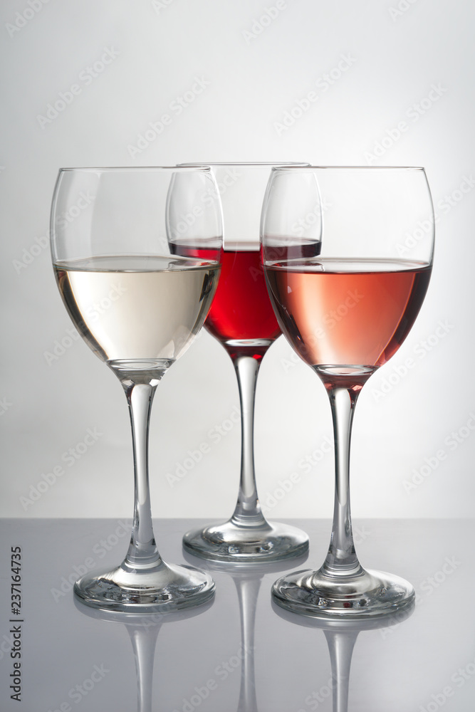 Glasses with different kinds of wine on grey table
