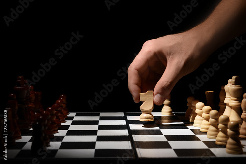 Man playing chess on dark background