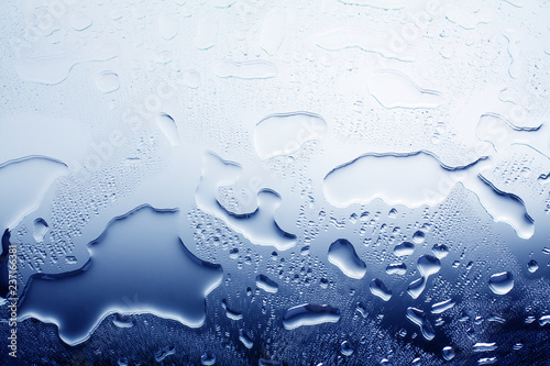 Wet glass surface in water drops, blue gradient, illustration of cool or cold water, texture of spilled water, abstract background, layout, banner, wallpaper, condensate drops on glass close up macro