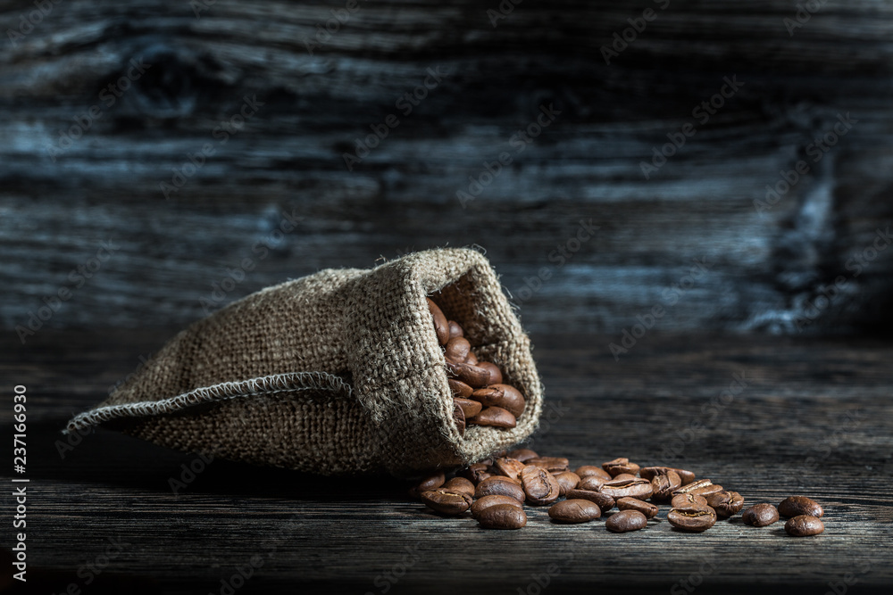 Fototapeta premium coffee beans scattered from sack.
