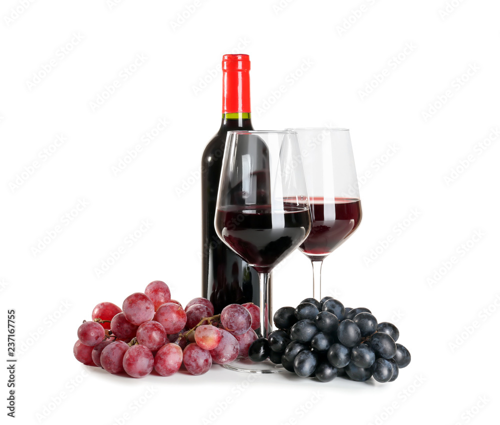 Glasses and bottle of red wine with ripe grapes on white background