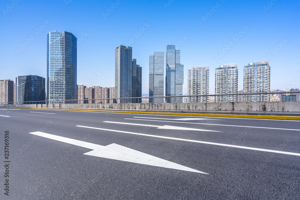 empty asphalt road with city skyline empty asphalt road with city skyline