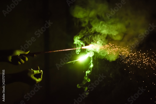 Fototapeta Naklejka Na Ścianę i Meble -  Fun with sparkler. Lady holding fire-sticks.