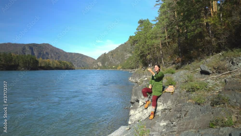 Two videos in one.Altai. Mountain lake. Fall. The woman the traveler in tourist boots goes on the coast of the lake. Close up. Two videos in one.Altai. Mountain lake. Fall. The woman the traveler in tourist boots goes on the coast of the lake. Close up.
