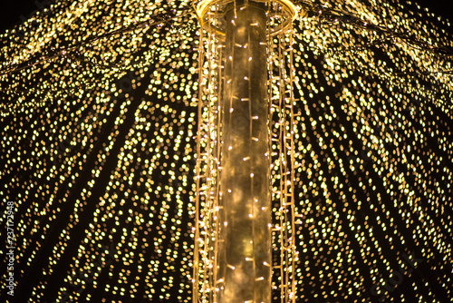 Abstract Christmas tree, colorful, blurry background. Glowing and sparkling lights in city center in Christmas market 