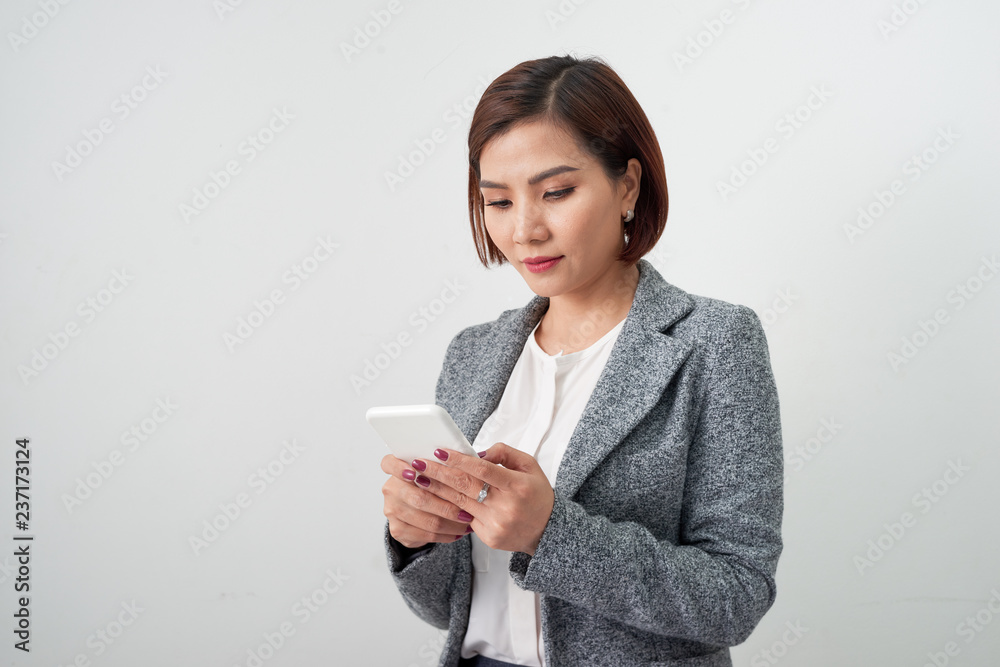Smiling businesswoman using smartphone over white background. Smiling businesswoman using smartphone over white background.