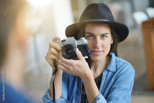  Trendy stunning brunette taking photos of model with vintage camera © goodluz