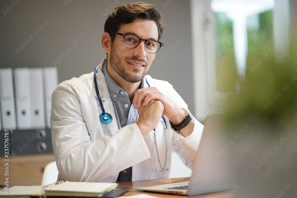  Handsome doctor in lab coat at office
