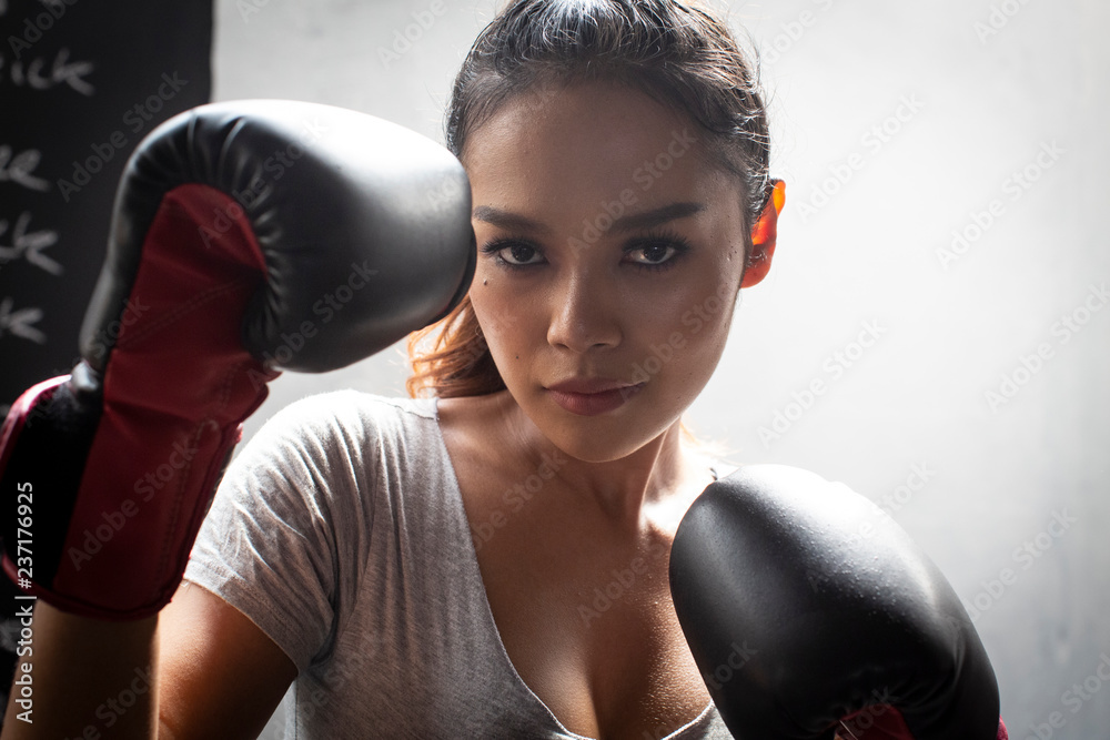 Thai transgender model in a Thai Box (Muay Thai) gym wearing boxing gloves