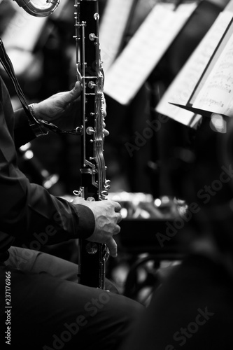 Hands of a musician playing bass clarinet closeup in black and white tones