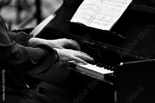 Hands of a woman playing in celeste close up in black and white