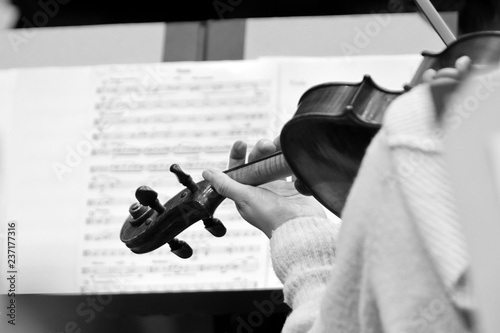 The hand of a girl playing the violin in black and white tones