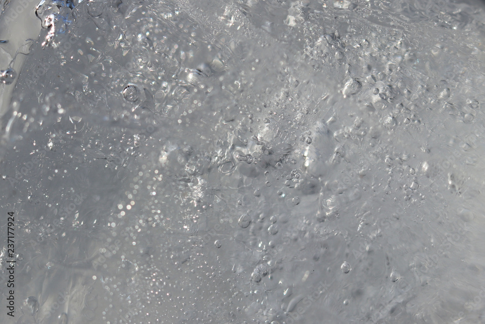 Texture and background of frozen water. A piece of ice with small bubbles of water. Cold atmosphere. Material for design in the winter. Texture and background of frozen water. A piece of ice with small bubbles of water. Cold atmosphere. Material for design in the winter.