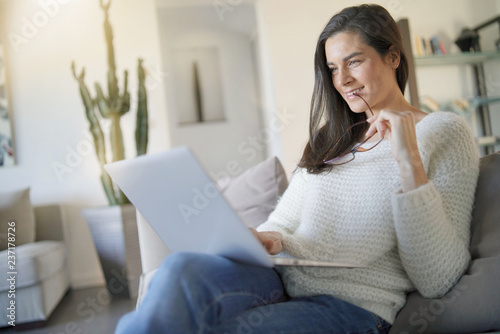  Beautiful woman relaxing at home with laptop © goodluz