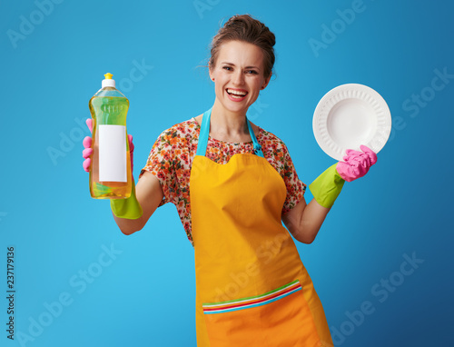 Obraz na płótnie happy housewife with washed plate showing dishwashing liquid