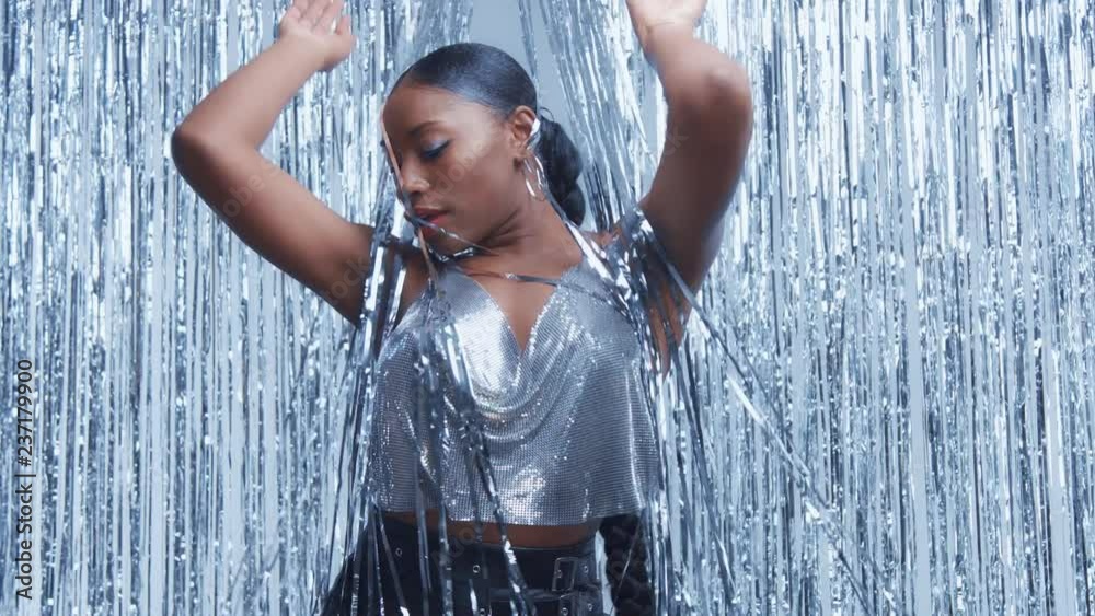 Slow motion black mixed race goes out behind the silver rain curtain and dancing
