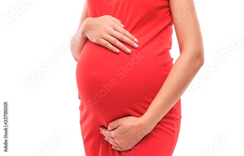 Pregnant woman gently hugs her belly. Close-up.