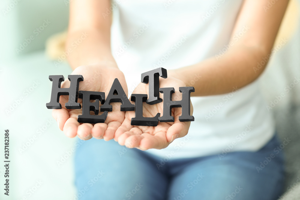 Woman holding black letters, closeup. Health care concept