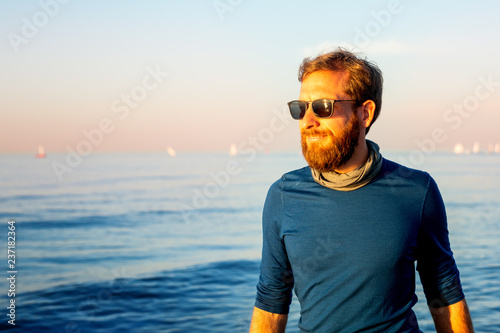 Junger Mann spaziert am Strand 