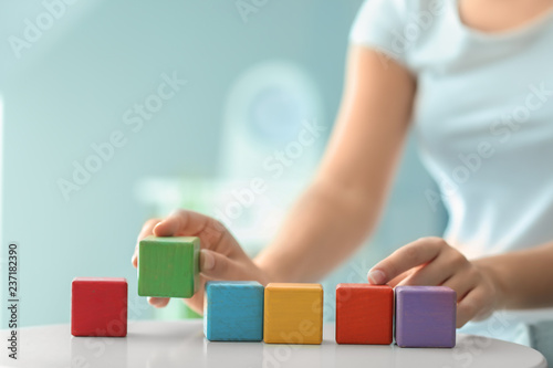 Woman with color cubes at light table, closeup