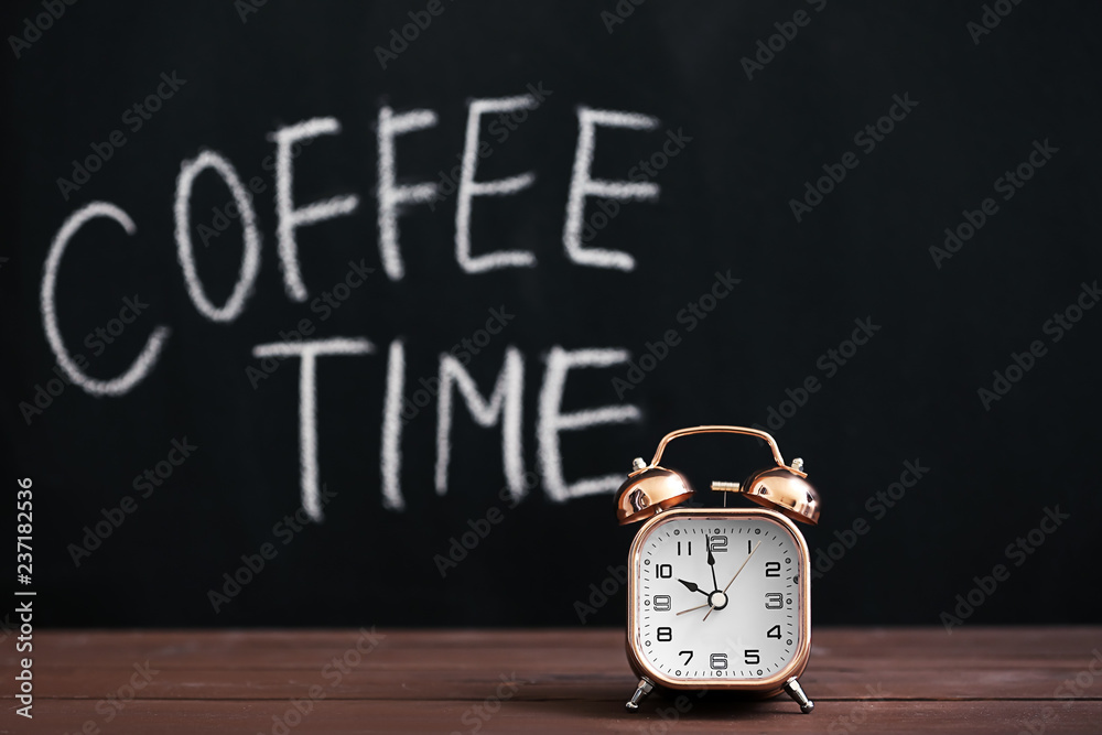 Alarm clock on wooden table against dark background Alarm clock on wooden table against dark background