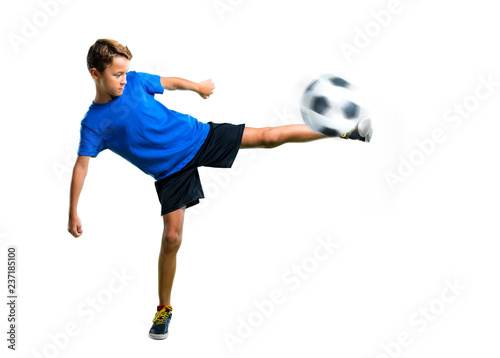 A full-length shot of Boy playing soccer kicking the ball on isolated white background © luismolinero