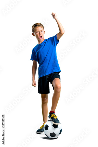 A full-length shot of Lucky boy playing soccer on isolated white background